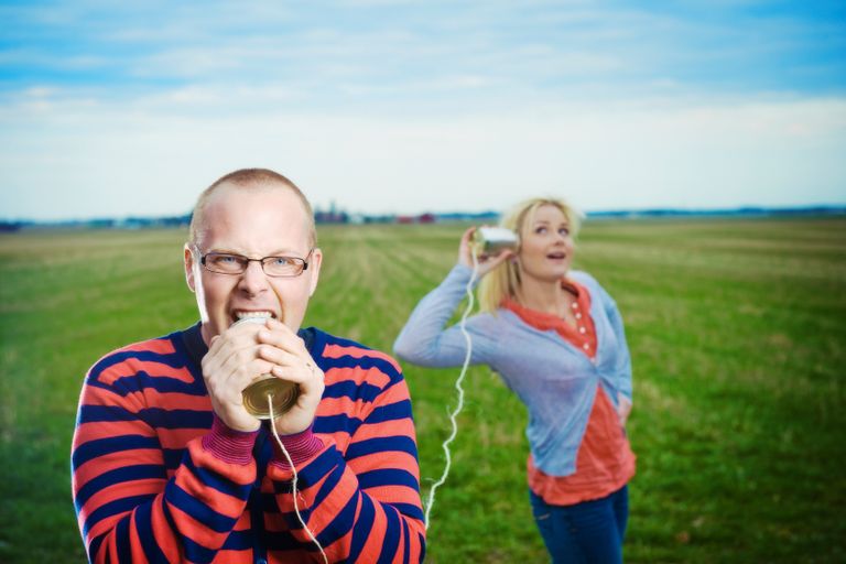 Mann und Frau nutzen ein selbst gebasteltes Schnurtelefon